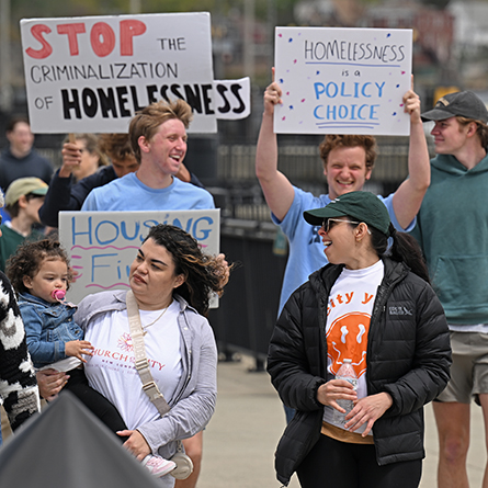 Students carry signs while participating in the Walk to End Homelessness