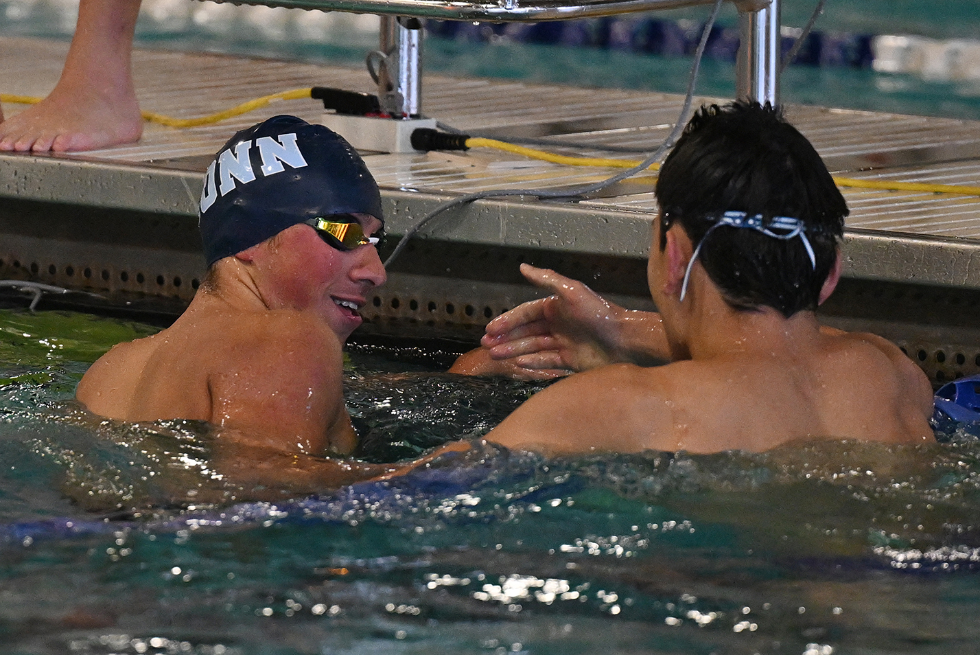 Two swimmers shake hands after a race.