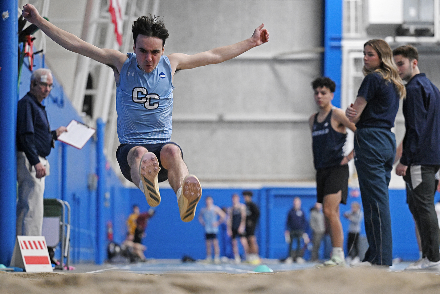 A student athlete competes in the long jump at a track meet.